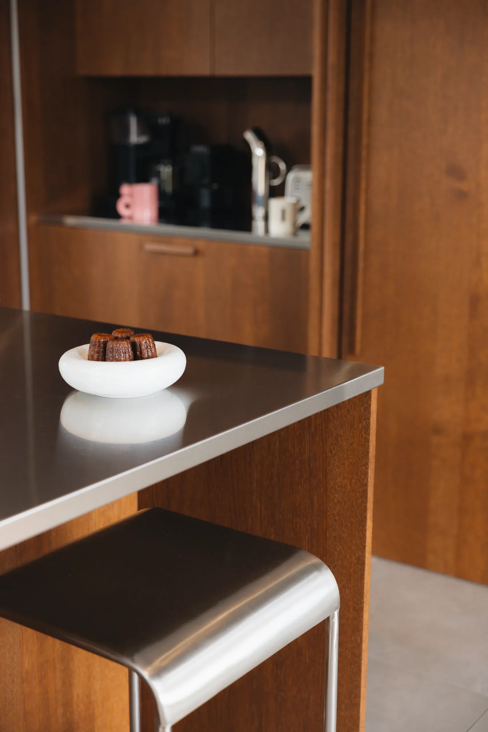 Plan de travail inox brossé Cuisines Morel — coin de plan avec bol blanc et canelés