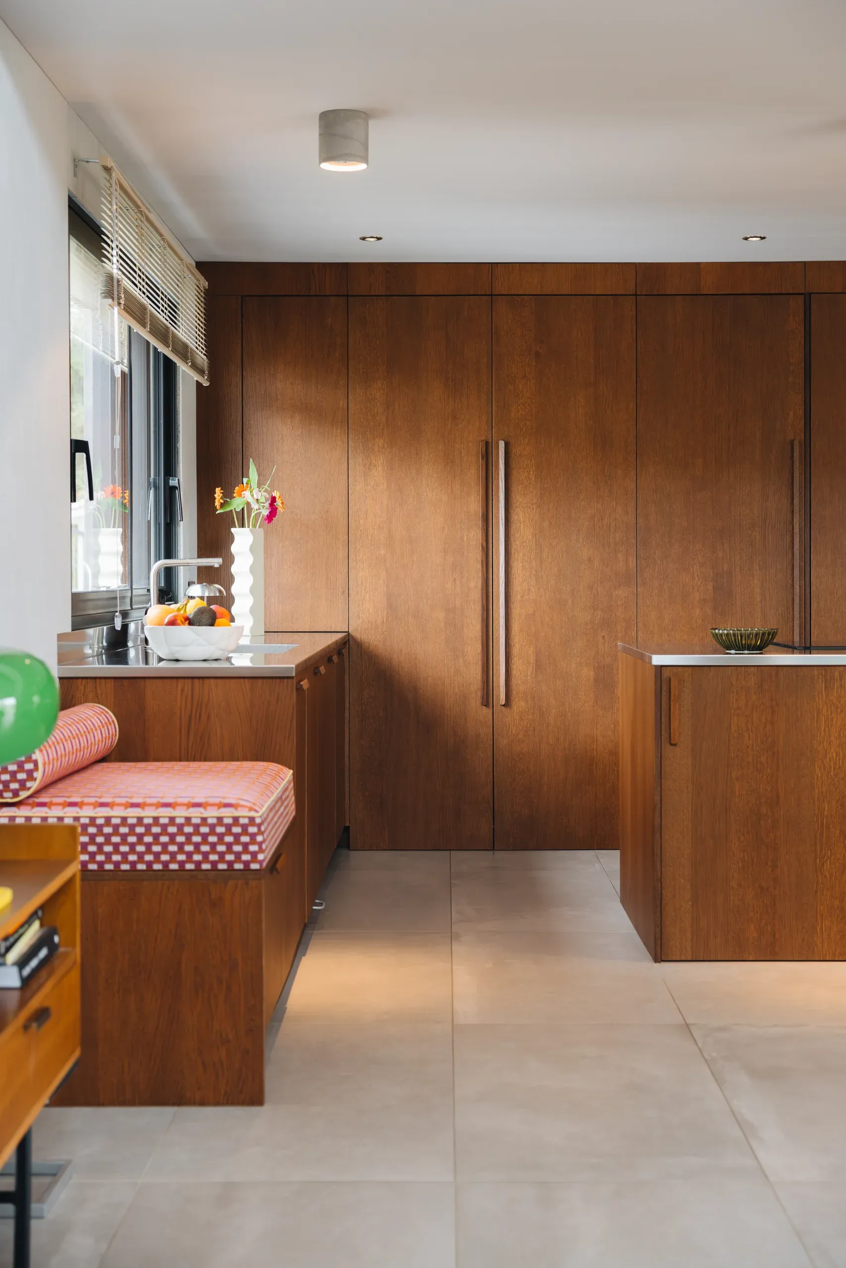 Cuisine teinte noyer — perspective ouverte vers le salon et meuble en continuité